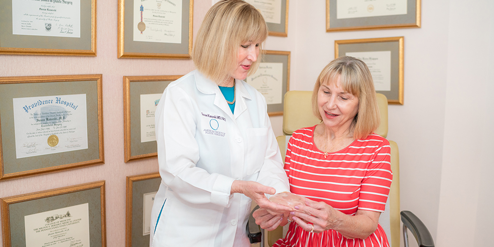 Dr. Kaweski Shows Breast Implant to Patient During Breast Augmentation Consultation